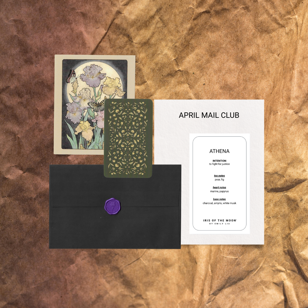 April Mail Club packaging with a card, envelope, and Athena card on a textured brown background