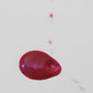 Magenta-colored oil spillng onto a white background