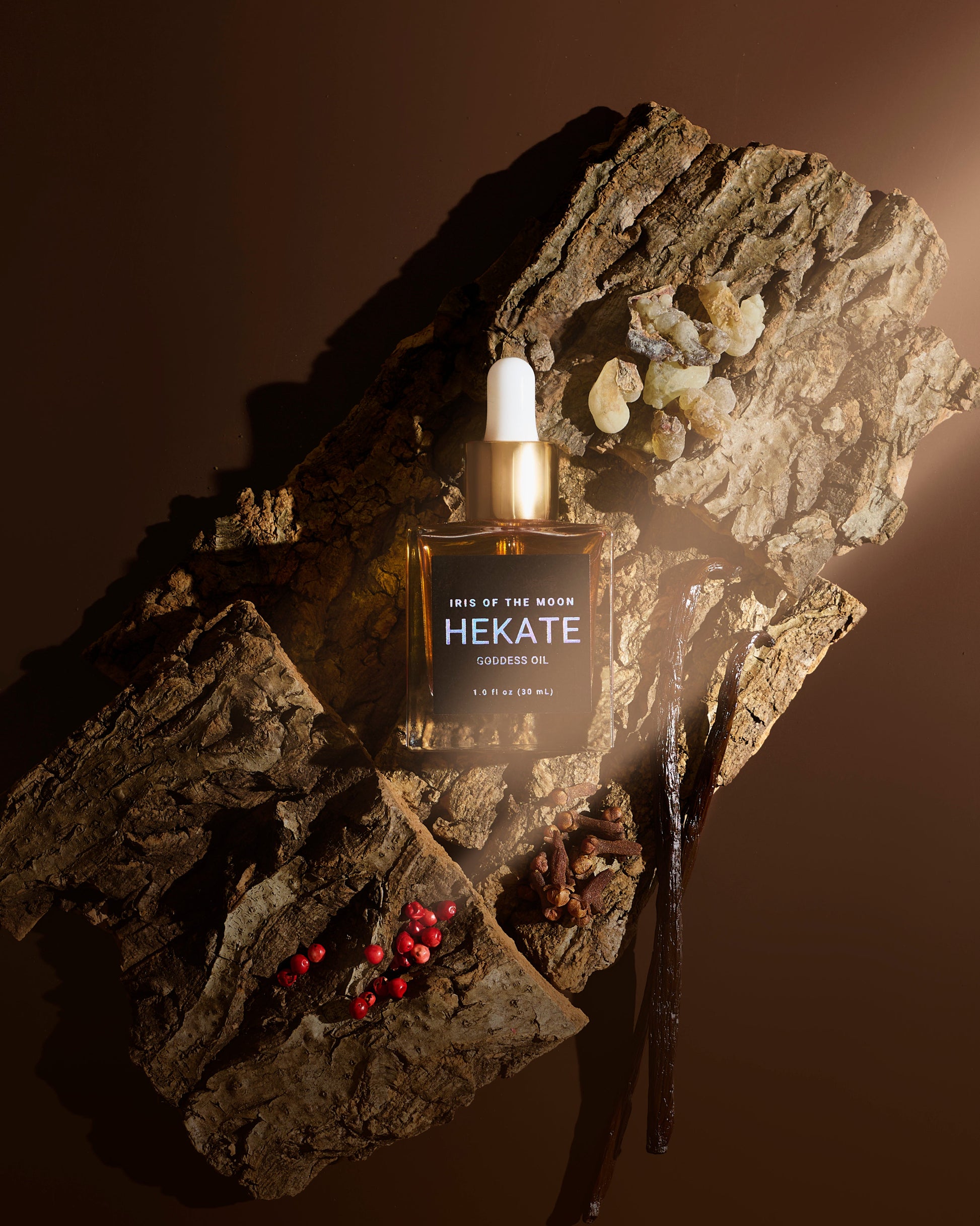 Hekate perfume bottle on a textured rock surface with a warm brown background