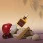 Perfume bottle labeled 'Lilith' with an apple and stones on a gradient background