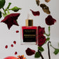 Persephone scented body oil bottle with red roses and pomegranate on a light background