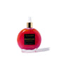 A circular glass bottle filled with shimmering, vibrant pink "Persephone" scented body oil is centered on a white background, featuring a gold cap and a white dropper.
