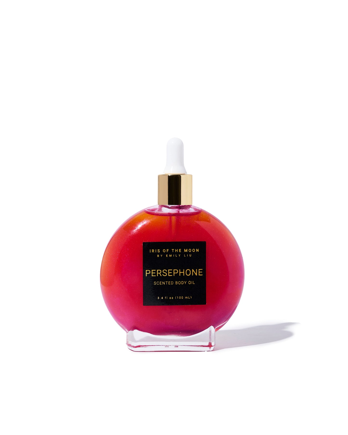 A circular glass bottle filled with shimmering, vibrant pink "Persephone" scented body oil is centered on a white background, featuring a gold cap and a white dropper.
